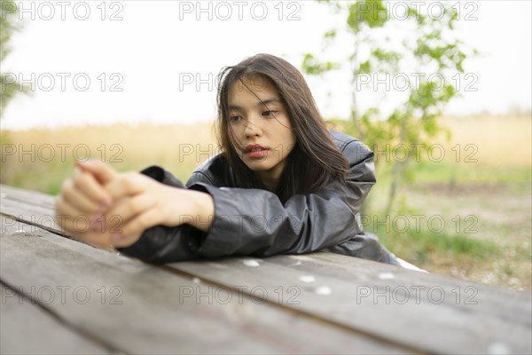 Portrait of teenage girl leaning on picnic table