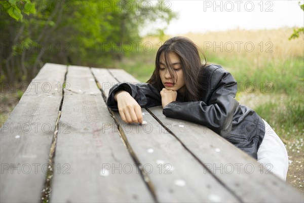 Portrait of teenage girl leaning on picnic table