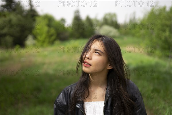 Portrait of teenage girl looking up in forest