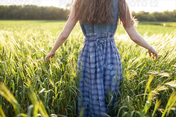 Rear view of woman walking in field