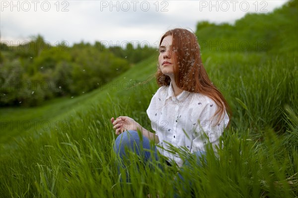 Portrait of serious teenage girl sitting on grass