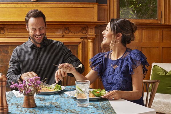 Smiling couple enjoying dinner at home