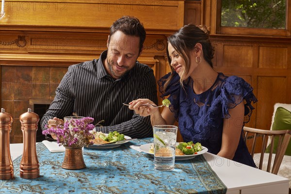 Smiling couple enjoying dinner at home