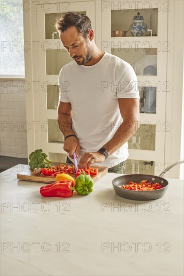 Man cutting vegetables in kitchen