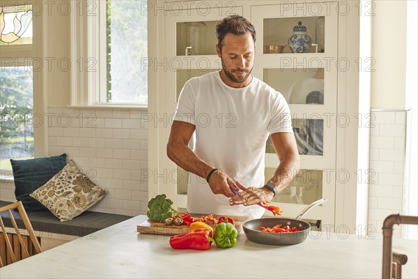 Man cutting vegetables in kitchen