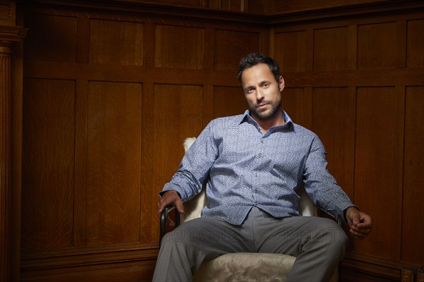 Portrait of mid adult man sitting on chair