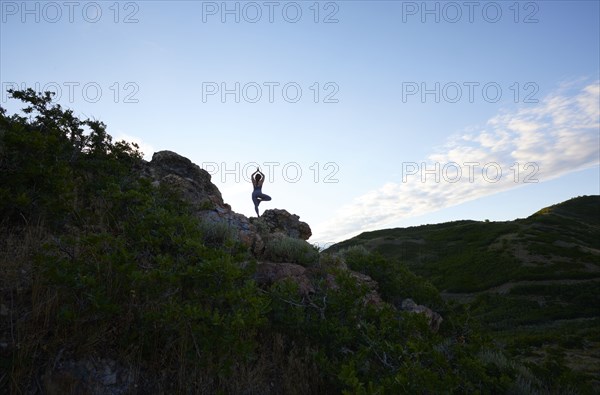 Mid adult woman doing yoga in mountains