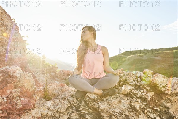 Mid adult woman meditating in mountains