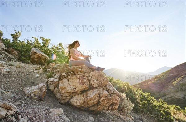 Mid adult woman resting on rock during hike