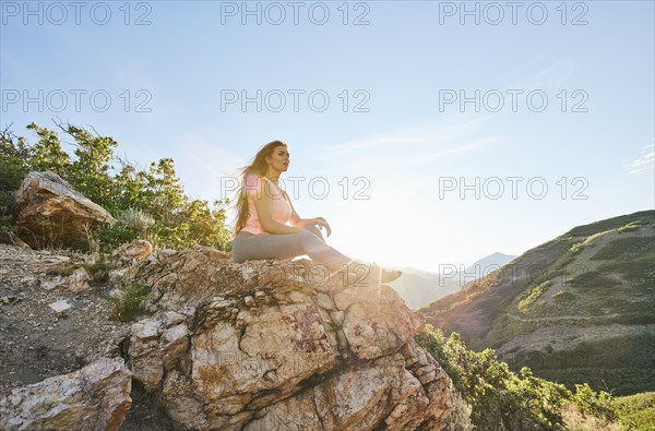 Mid adult woman resting on rock during hike