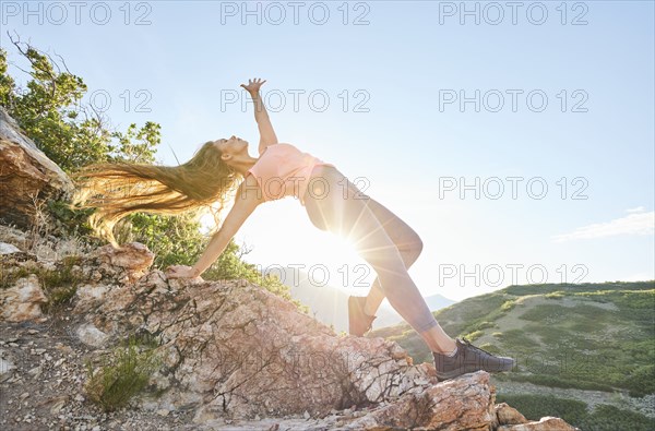 Mid adult woman doing yoga in mountains