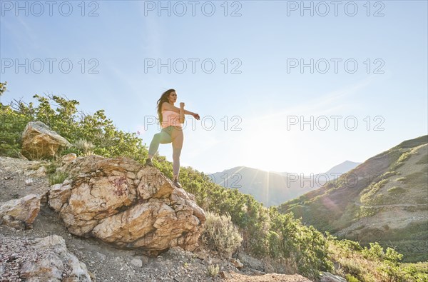 Mid adult woman stretching during hike