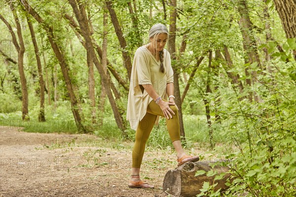 Mature woman experiencing knee injury while in park