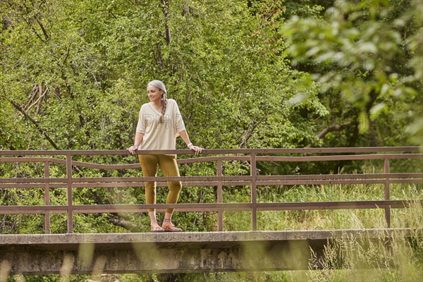 Mature woman standing on bridge in nature