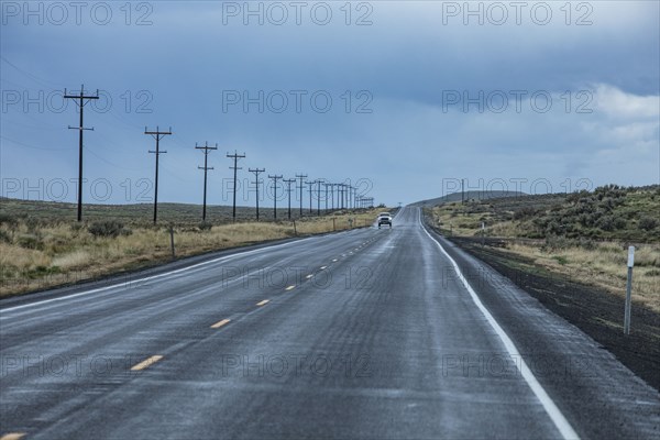 Electricity pylons along highway during stormy weather