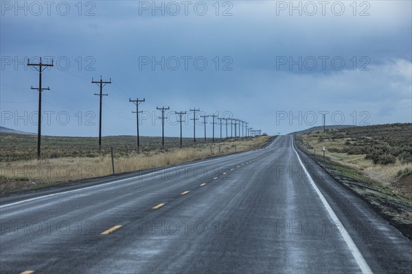 Electricity pylons along highway during stormy weather