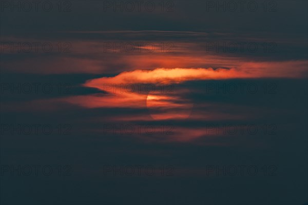 Sun behind clouds at sunset