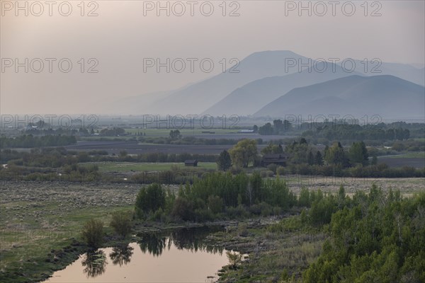 Landscape with small pond and mountains in background