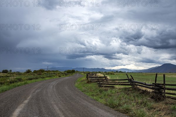 Dramatic clouds above empty road and meadow