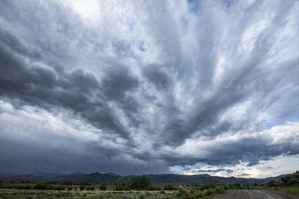 Storm clouds above landscape with meadow