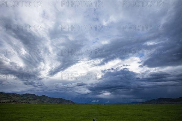 Storm clouds above landscape with meadow