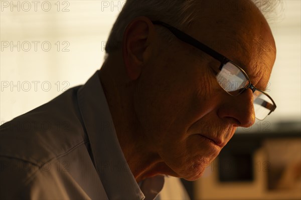 Portrait of thoughtful senior man looking down at home