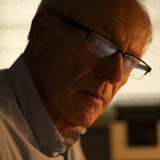 Portrait of thoughtful senior man looking at camera at home