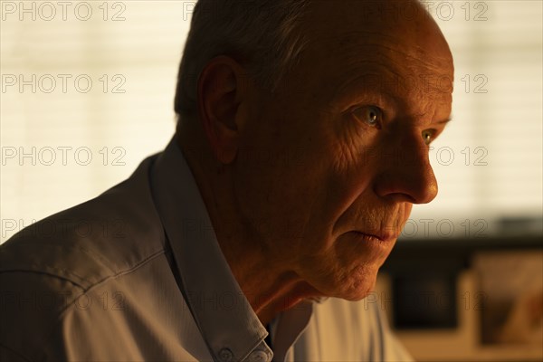 Portrait of thoughtful senior man looking away at home