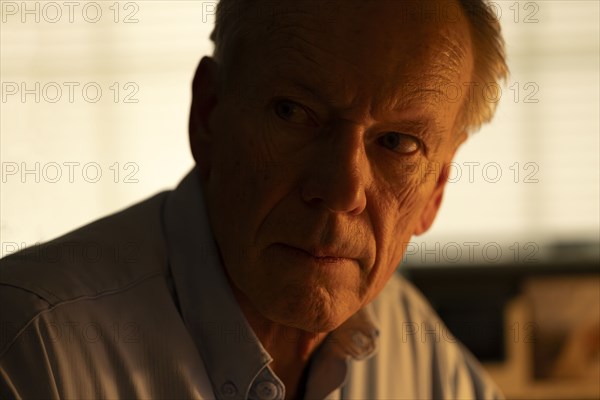 Portrait of thoughtful senior man looking away at home