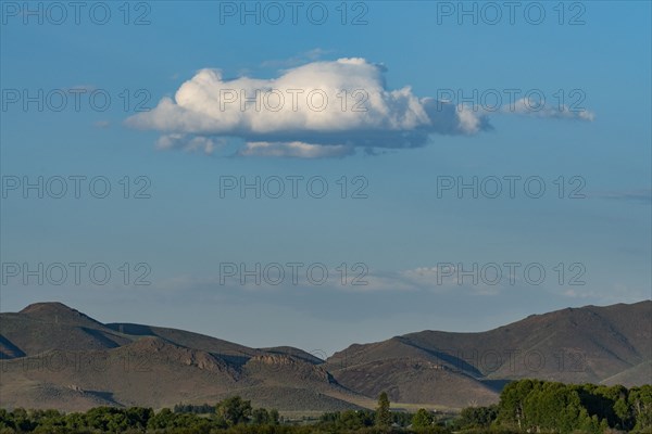 Cloud floating over foothills on sunny day