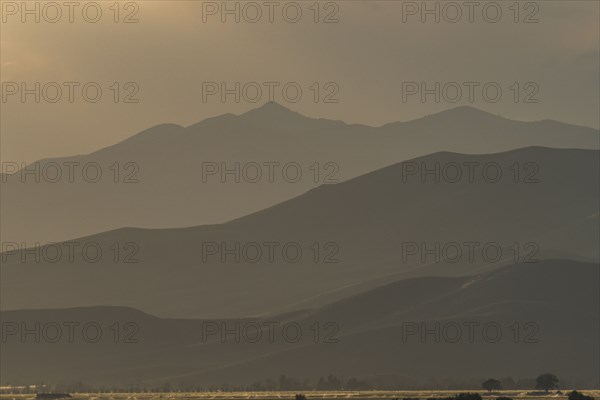 Mountain landscape in fog at sunset
