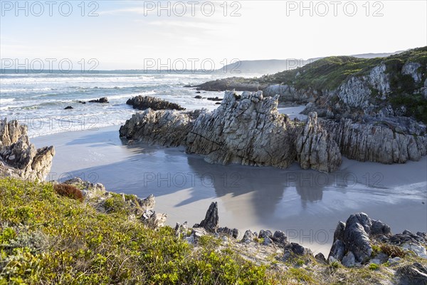 Rocky coastline with Atlantic Ocean in Voelklip Beach on sunny day