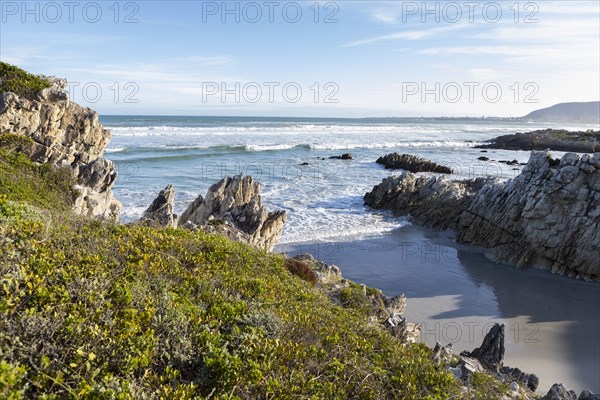 Rocky coastline with Atlantic Ocean in Voelklip Beach on sunny day