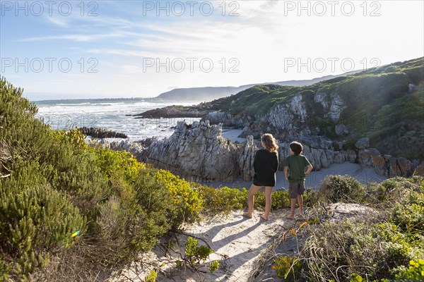 Brother and sister looking at Atlantic Ocean in Voelklip Beach