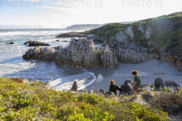Brother and sister exploring rocky coastline in Voelklip Beach