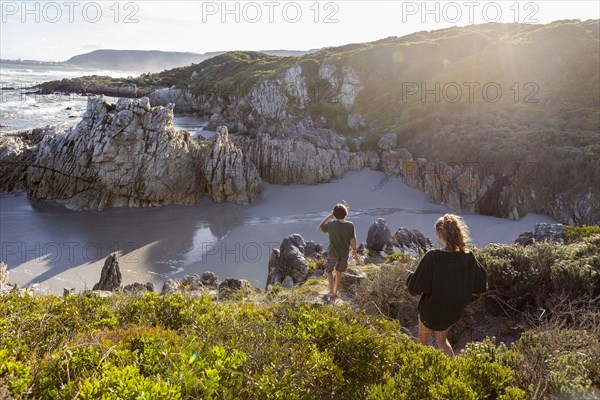 Brother and sister exploring rocky coastline in Voelklip Beach