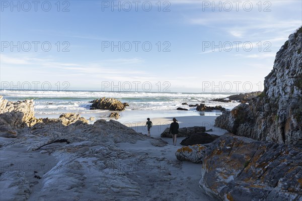 Brother and sister exploring rocky coastline in Voelklip Beach