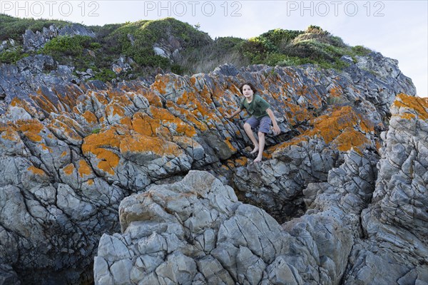 Boy standing on rock in Voelklip Beach