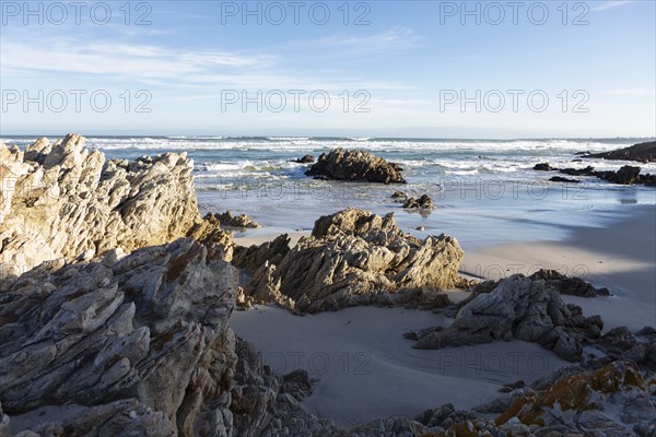 Rocky coastline with Atlantic Ocean in Voelklip Beach on sunny day