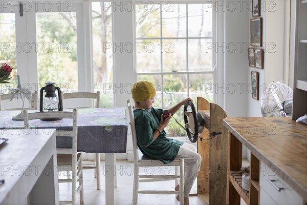 Boy pretending to drive homemade steering wheel