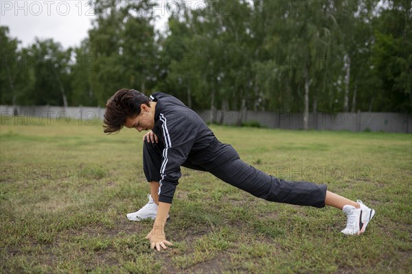 Young woman stretching legs before workout
