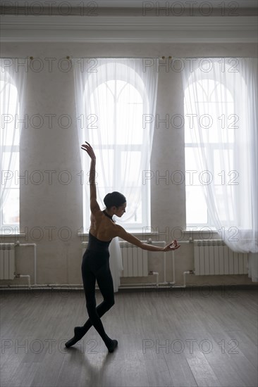 Back view of ballerina dancing at studio