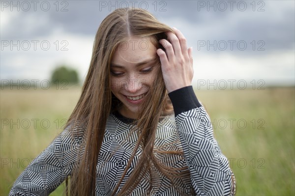 Smiling young woman standing in field