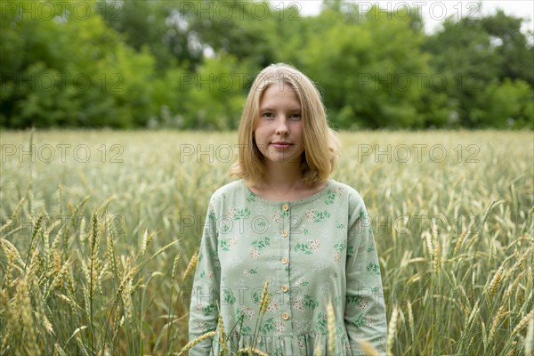 Young woman standing in wheat field in summer