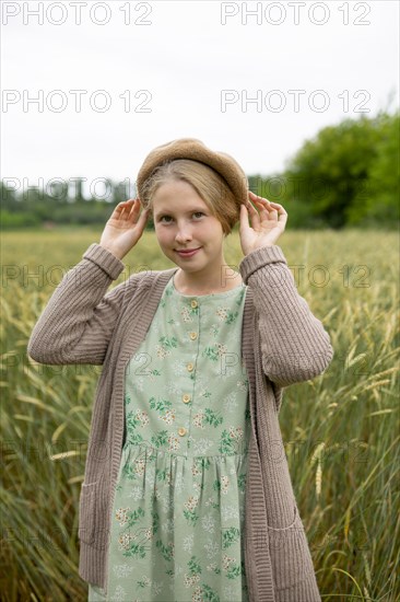 Portrait of young woman wearing beret standing in wheat field