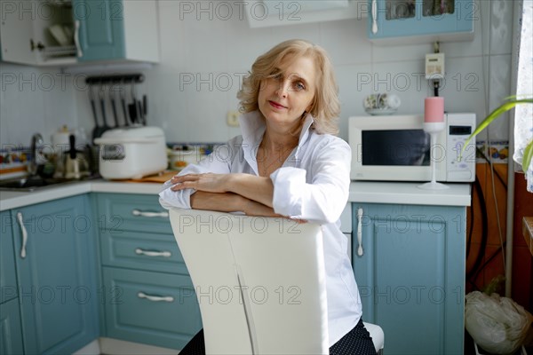 Woman sitting on chair in kitchen