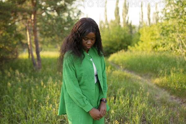 Brunette woman standing in meadow and looking down