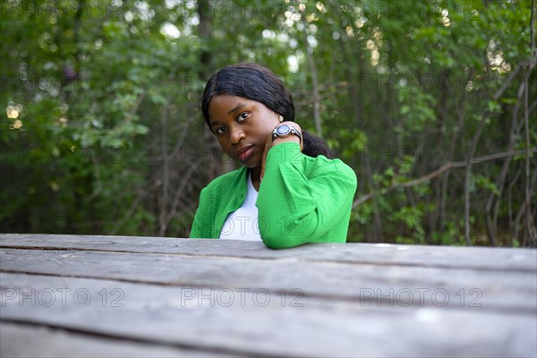 Woman looking at camera and sitting at picnic table