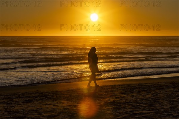 Silhouette of woman walking along Cannon Beach