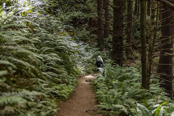 Woman walking on path in forest